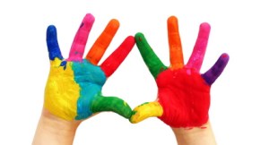 Child hands painted in colorful paints ready for hand prints